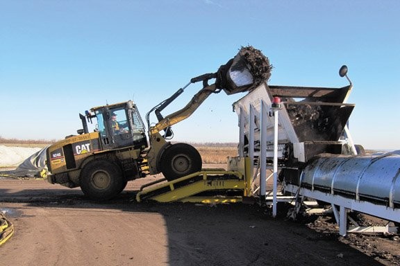 Dumping compost into the hopper at Peel's facility