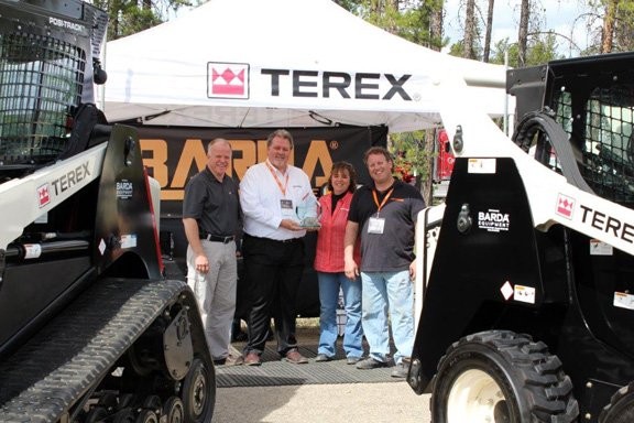 Terex sales manager Gregg Warfel, left, and Terex sales director Ken Doan present the Top-Performing Distributor award to Penny Batt, Barda general manager and Barda’s Barry Fenton, right.