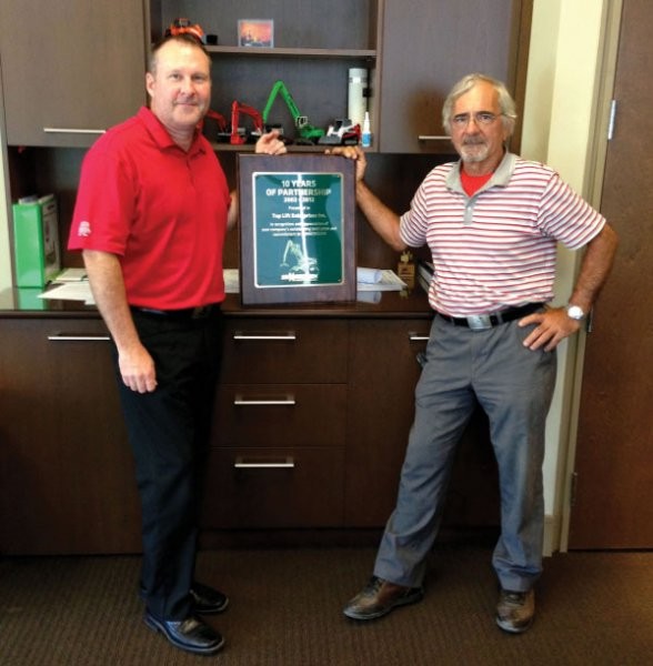 Top Lift's David Shea (L) and Emidio Greco proudly display their 10 year partnership award from Sennebogen. Top Lift's David Shea (L) and Emidio Greco proudly display their 10 year partnership award from Sennebogen.