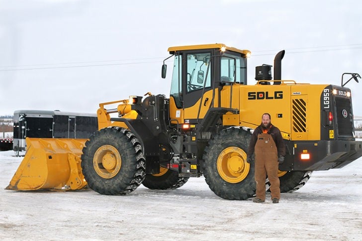 Cole Koch, superintendent and part-owner of Double K Excavating, in front of the company's snow-covered SDLG LG959.