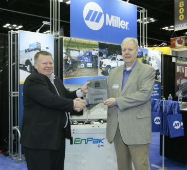 Roger Hornberger, director of marketing, Power Products Division for Miller Electric Mfg. Co. (right), accepts The Work Truck Show 2015 Green Award for the EnPak Power System from Steve Carey, NTEA executive director (left).