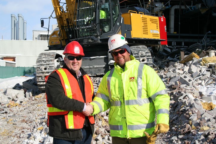 Aaron Hopkins, of Robert Green Equipment Sales Ltd. and Ryan Priestly, of Priestly Demolition Inc. shaking hands on the sale of the KOBELCO SK1000. 