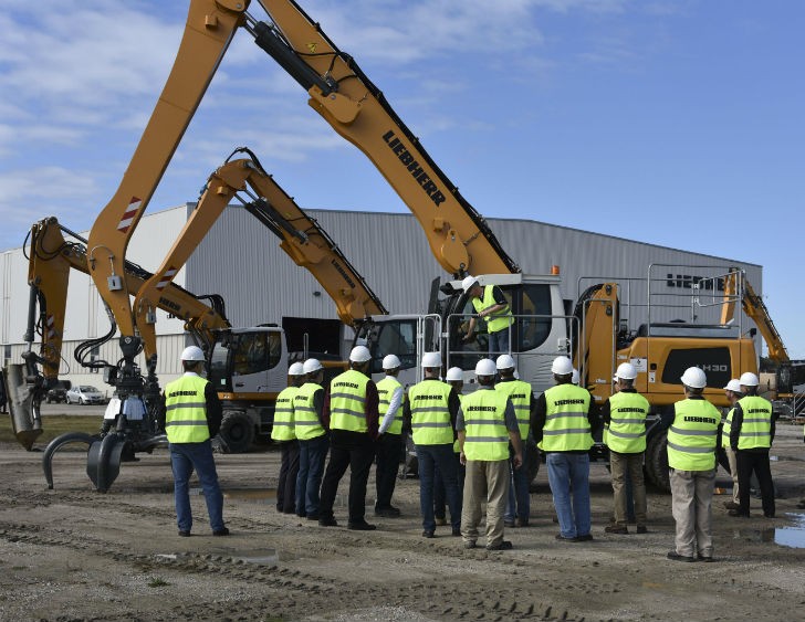 Dealers and sales professionals gather around the LH30 Material Handler for a walk around.
