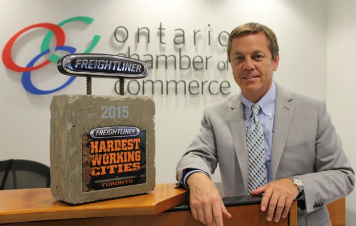 Allan O'Dette, president and CEO of the Ontario Chamber of Commerce, poses with Toronto Freightliner Trucks Hardest working Cities award.