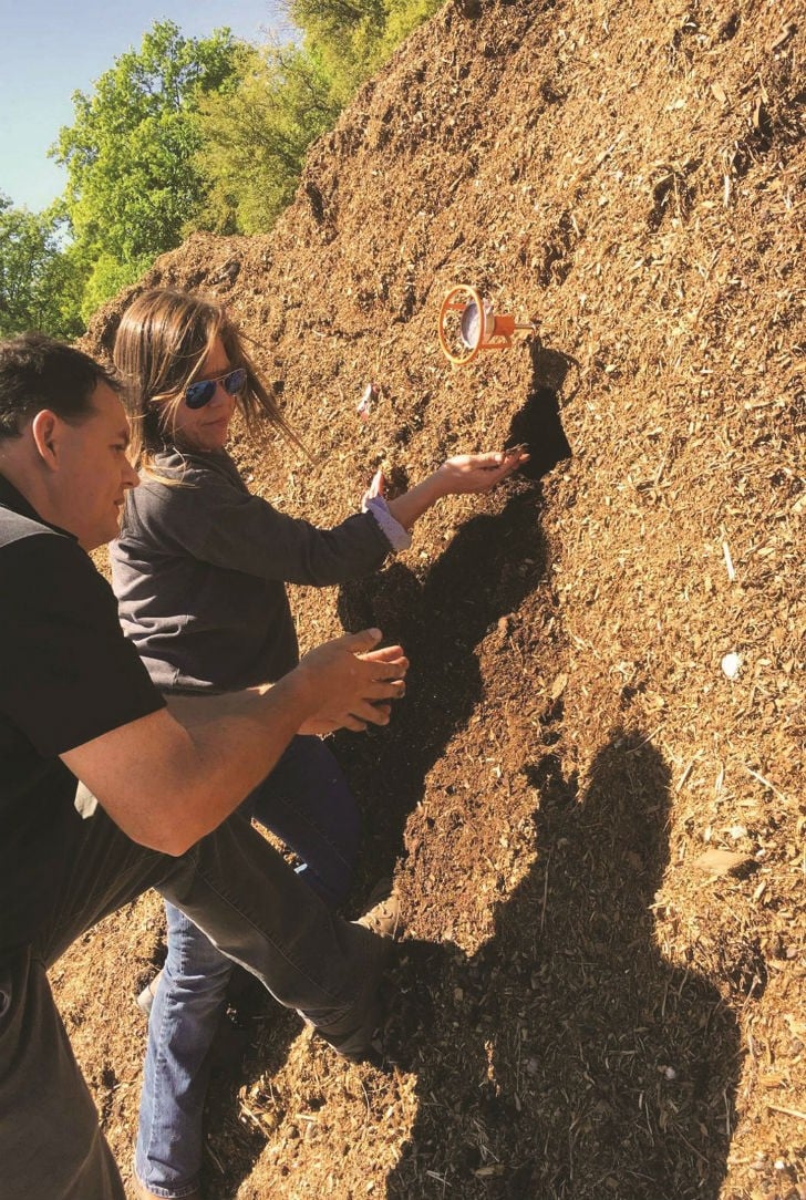 Darren Midlane, CTO of Harvest Quest, with Heather Mayer from Mayer Materials examining the quality of their compost.