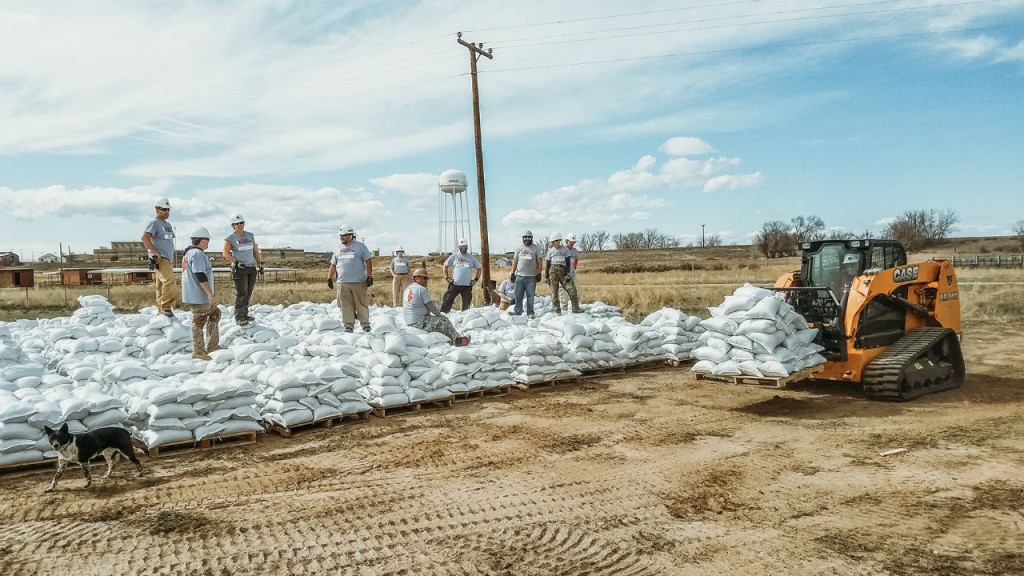 Team Rubicon crews work with a Case CTL to prepare for high waters in Fremont County, Wyoming.