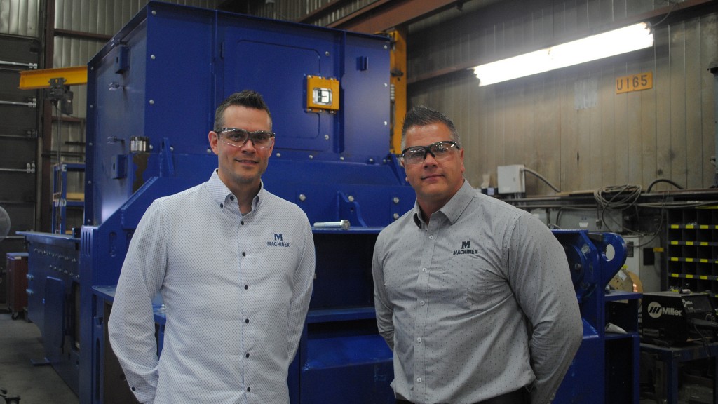 Left to right: Jonathan Fortier and Sébastien Delisle in front of a baler inside the Machinex manufacturing facility.