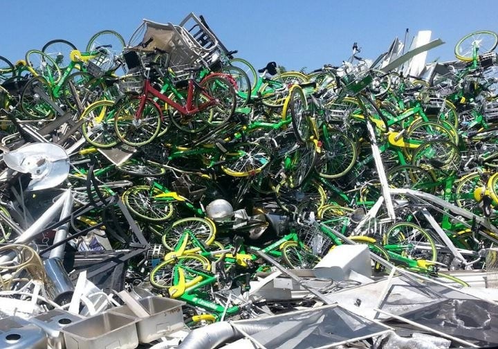 Lime Bikes piled high in a Denver scrap yard. Credit: Lime Bike Insider.