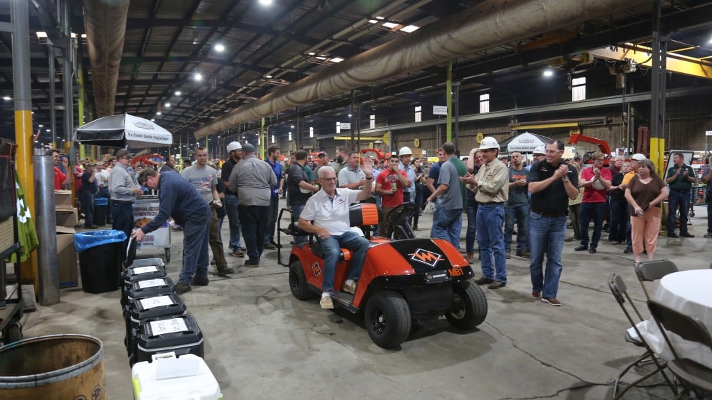 Larry Burkholder riding on a golf cart in warehouse.