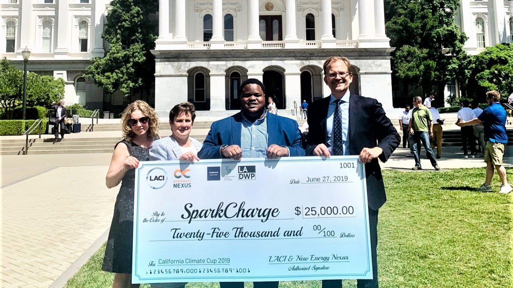 three people accept an award with big cheque