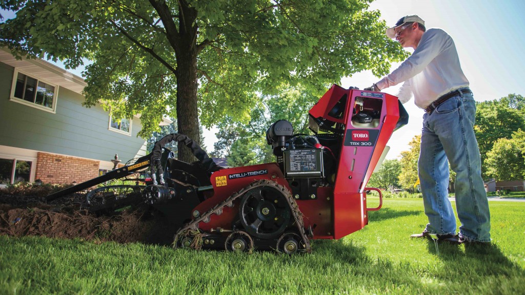 man working a walk behind trencher