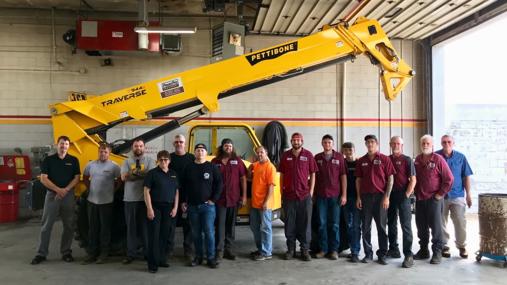 a group of men stand in front of a telehandler