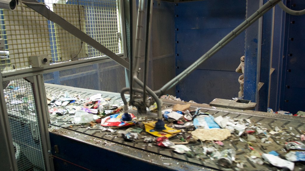 Cartons and containers on the belt, with an AMP robotic arm.