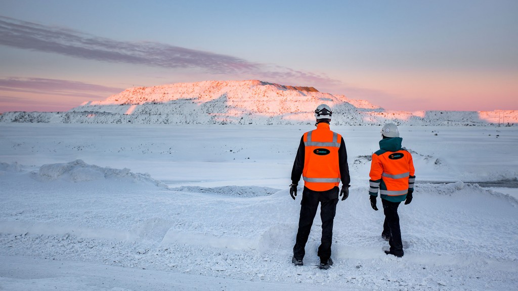 two metso workers survey snowy landscape