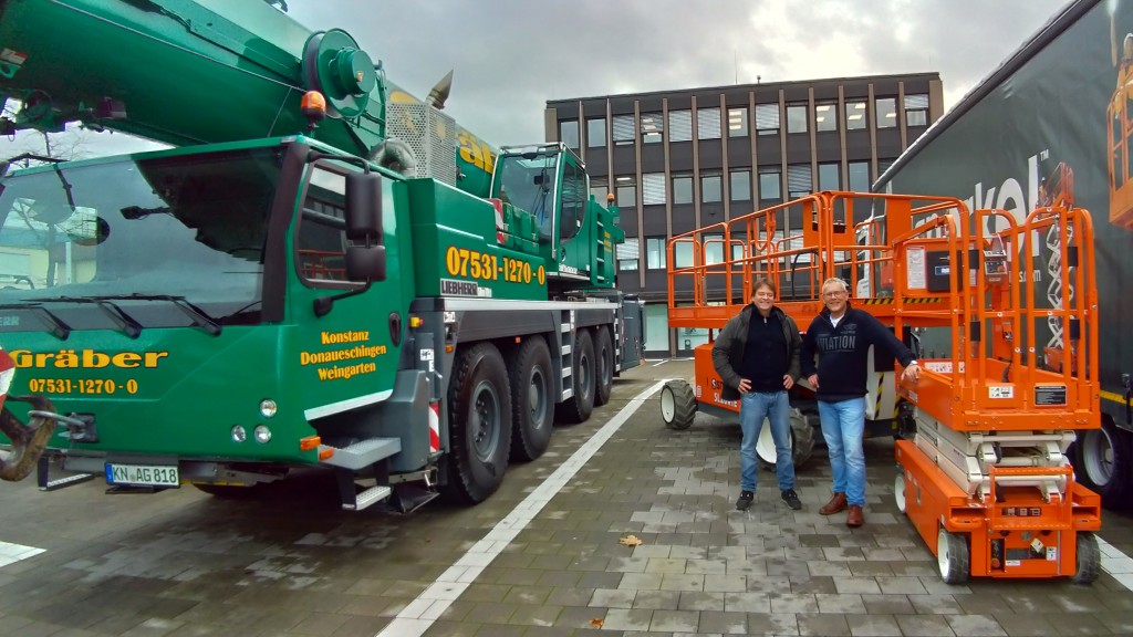 two men next to a snorkel lithium powered lift