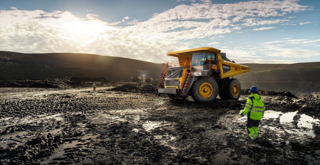 hauler at top of a hill with a worker looking on