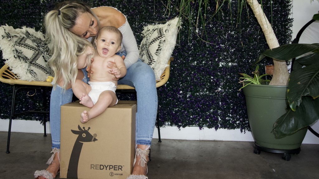 Mother kisses baby on a cardboard box