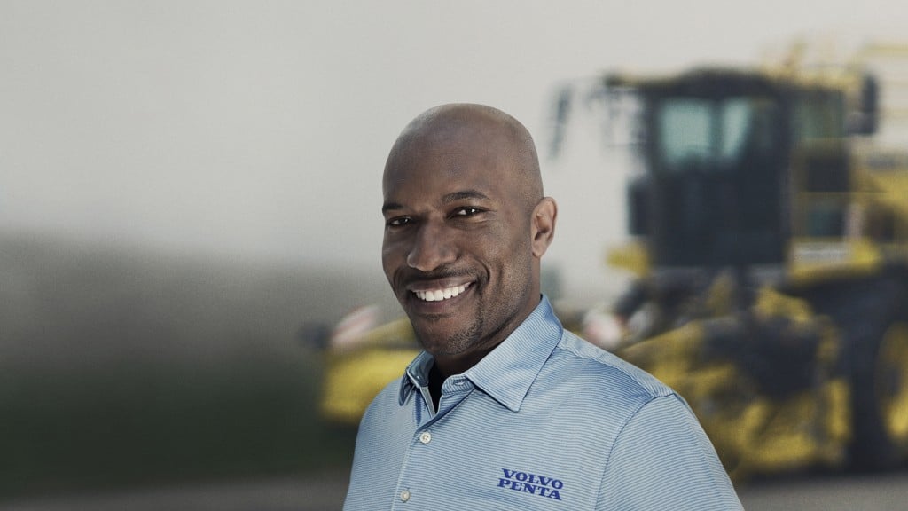 Volvo worker smiles in front of machine