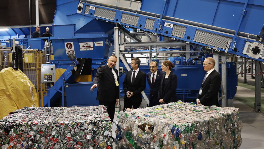 a group of people in front of Stadler machinery and blocks of plastic
