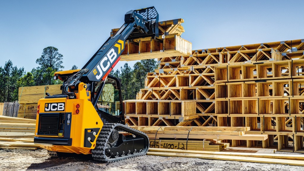 A JCB teleskid handles building materials on a jobsite