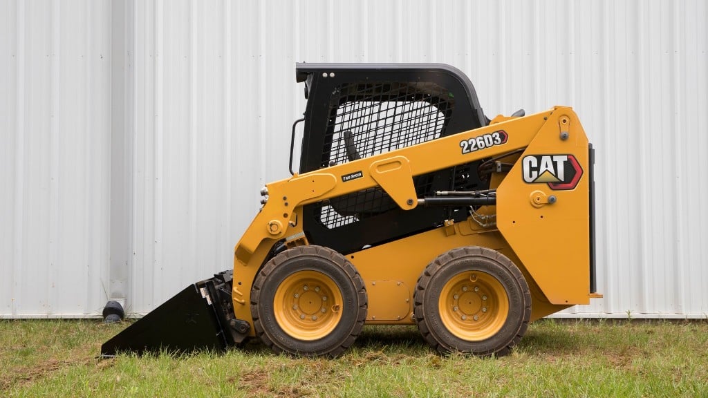 Cat skid-steer loader beside building