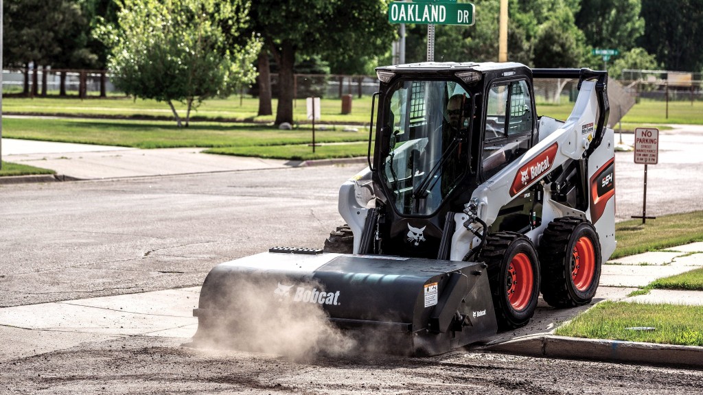 A Bobcat skid-steer loader with a sweeper attachment.