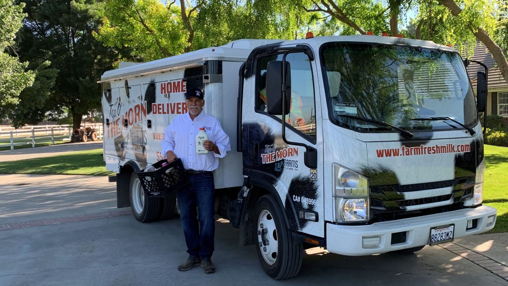 man standing outside of TopOMorn milk truck