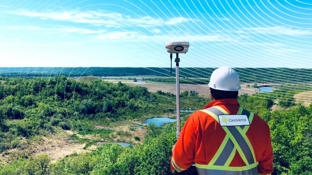 Geoverra worker using geospatial equipment looking over a valley