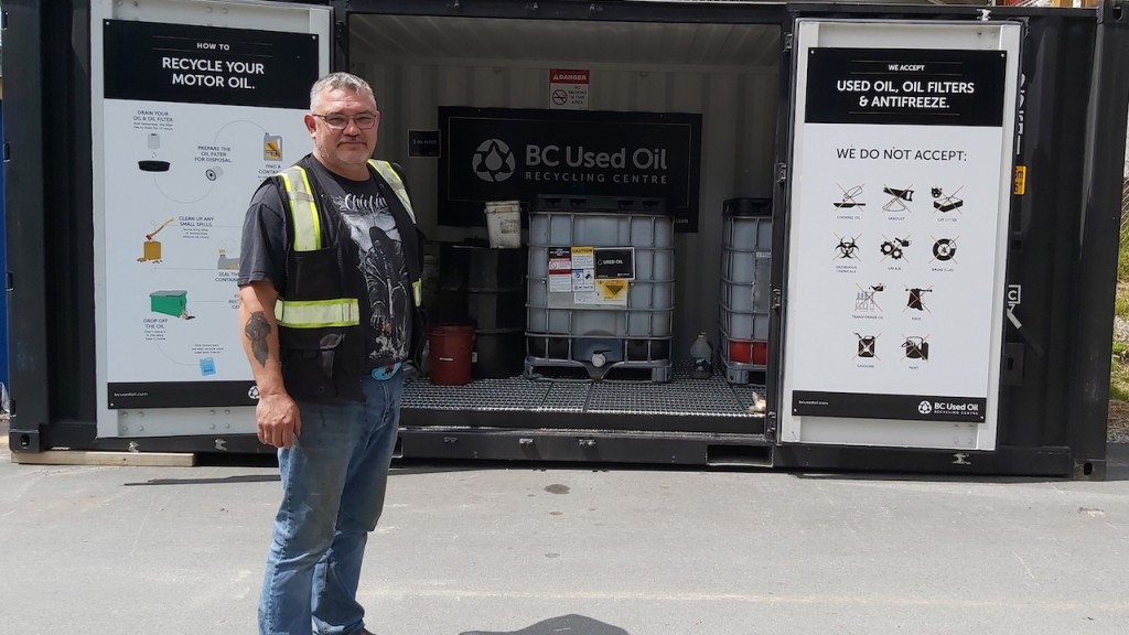 BC Used Oil worker next to a recycling centre