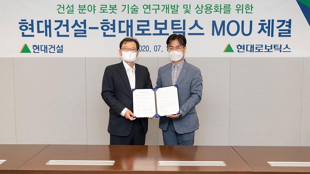 two masked men from Hyundai robotic pose for signing ceremony