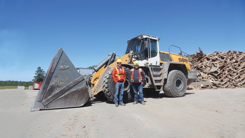 Christian Dietrich, GM of Ecowaste’s waste management division, and Shaun Salmon, site foreman, at the waste wood pile with their 566 wheel loader.