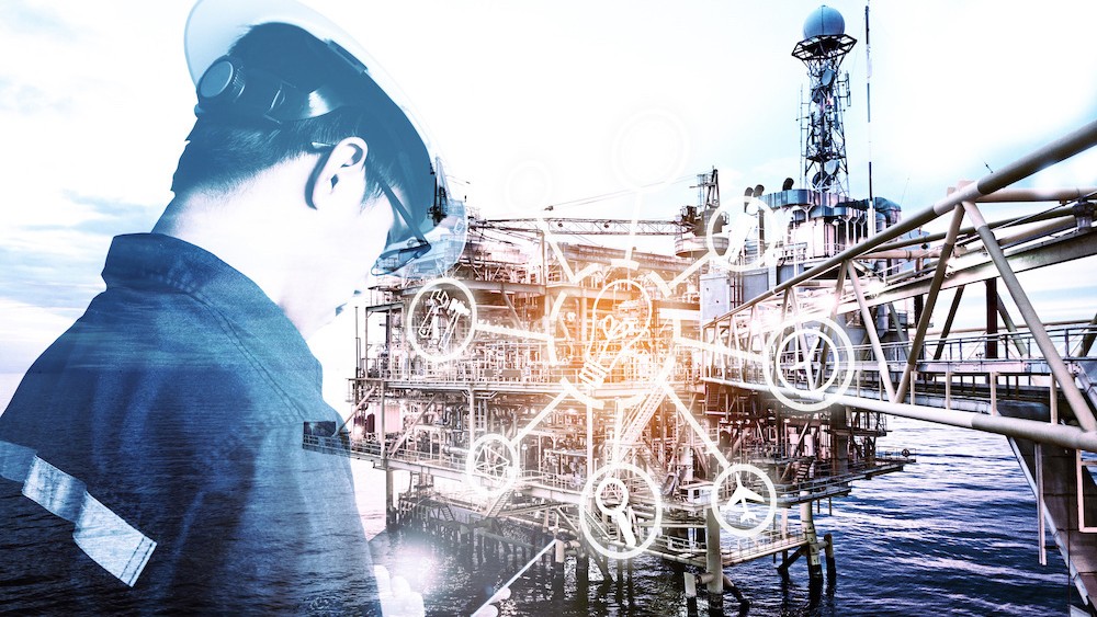 oil rig worker using a tablet near an oil rig oil rig worker using a tablet near an oil rig