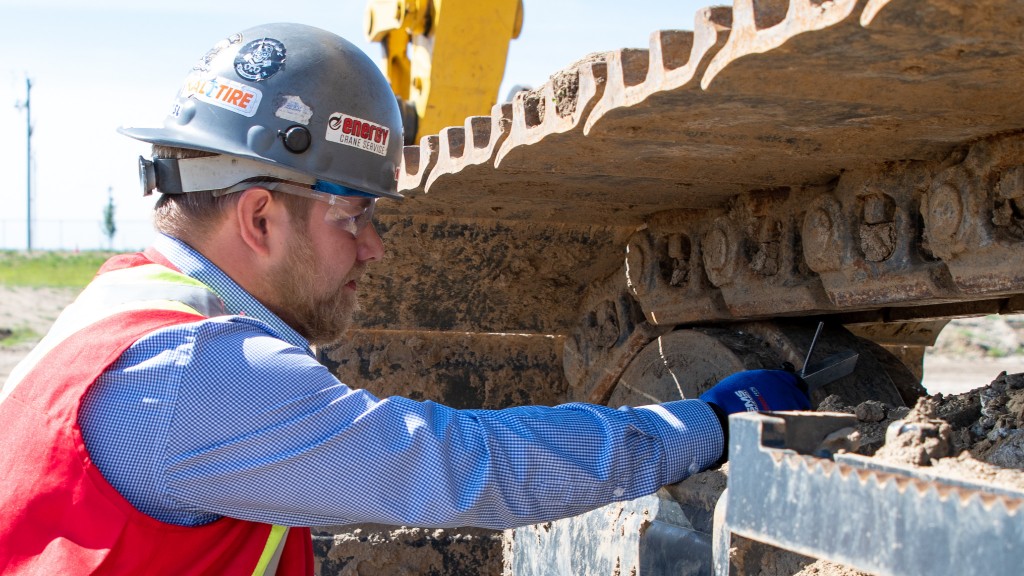 SMS Equipment's Travis Wolfe measuring an undercarriage.