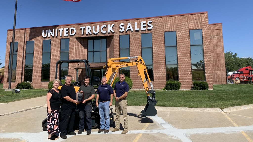 people stand in front of Hyundai machine and united truck sales facility