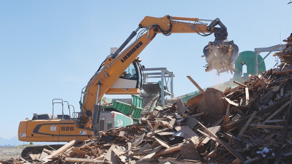 Liebherr’s R926 LC excavator with rising cab feeding C&D waste wood into the shredding line at Ecowaste in Richmond, B.C.