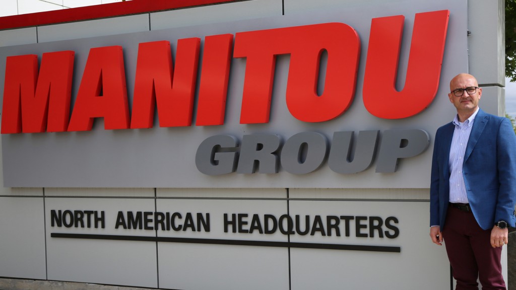 new appointee Ilmars Nartish stands next to Manitou group HQ sign