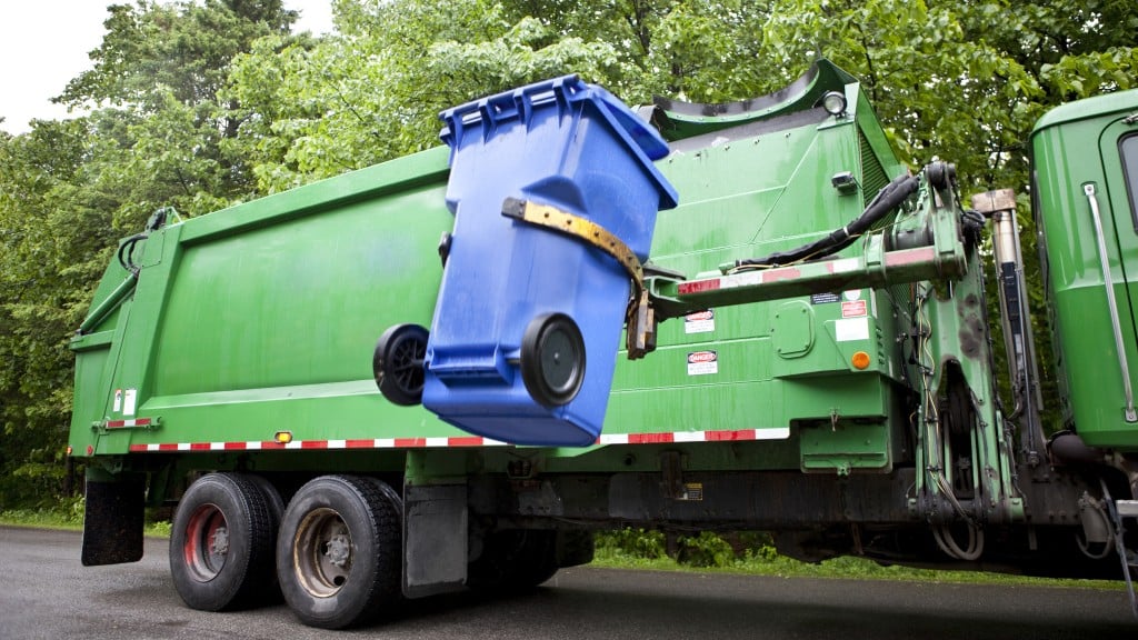 collection truck loading a blue bin in to the truck body