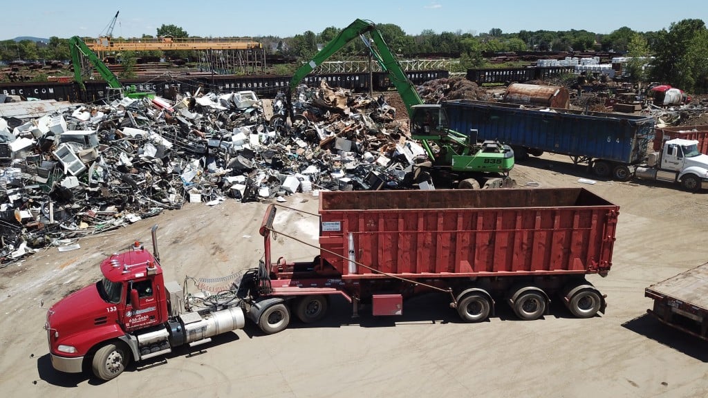 material loader in a scrap yard with a dump truck