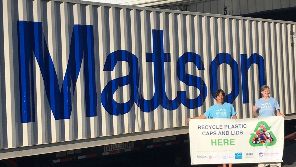 two people hold up a banner in front of semi trailer truck