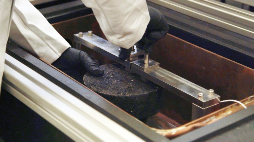 Researcher prepares asphalt specimen for the DCT (Disc Shaped Compact Tension) test