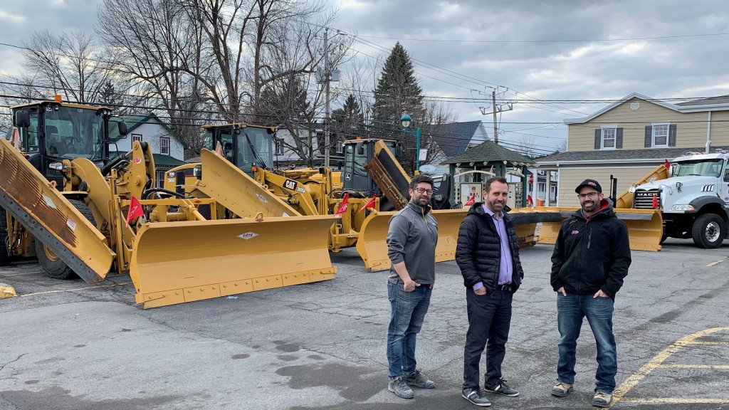 three men stand in front of machines