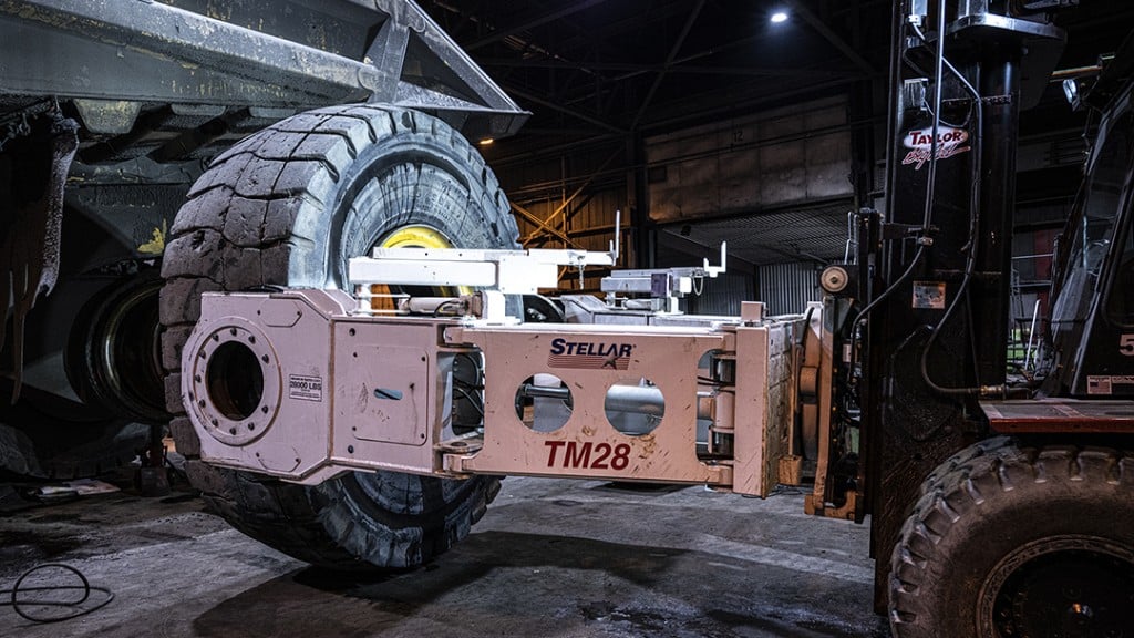 Stellar mining tire manipulator hooked to a mining machine