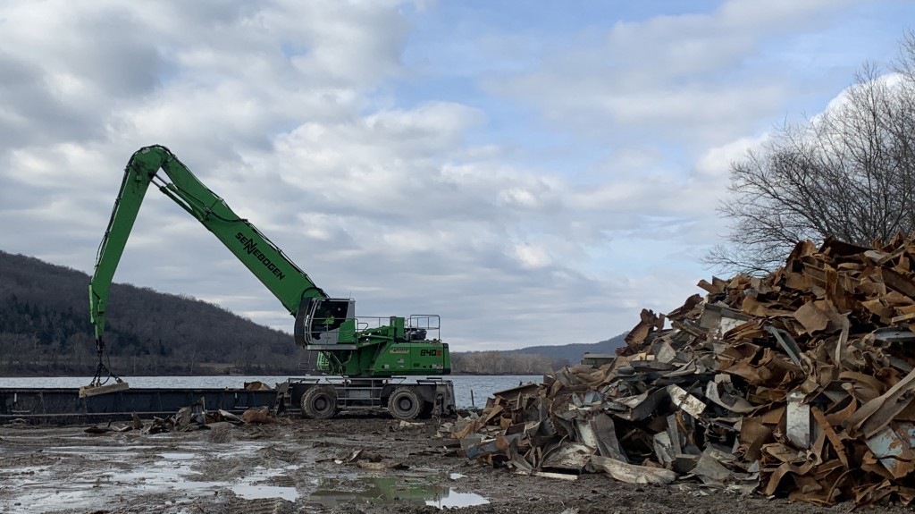 Sennebogen 840 M Material Handler at work in a junkyard next to a river