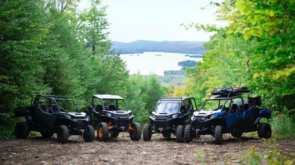 an array of Can-Am Commander vehicles on a forest road