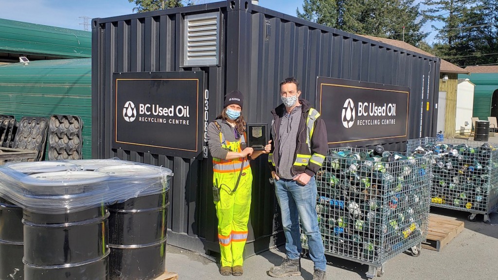 two people in masks stand outside a BC Used Oil recycling centre