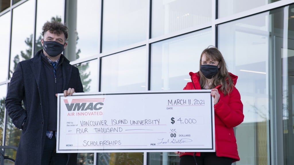 two people accept cheque from VMAC