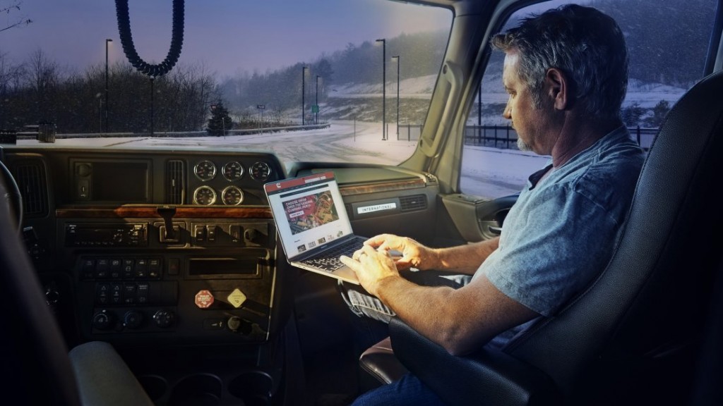 man using computer in a truck