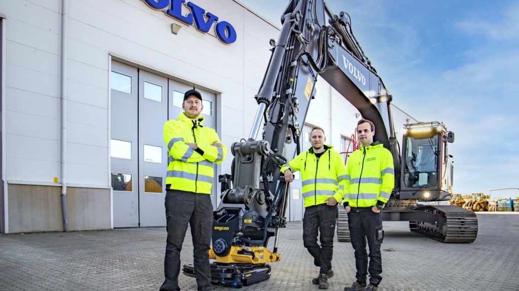 3 men stand next to Volvo CE machine