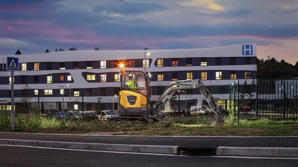 Volvo ECR25 doing work in front of building