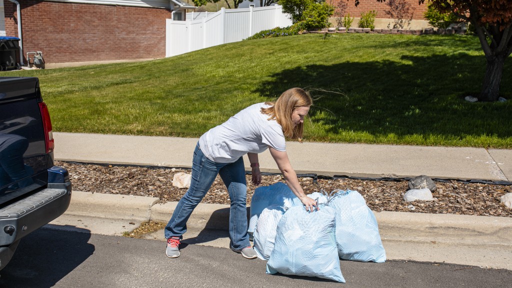 woman putting out Glad garbage bags on curb